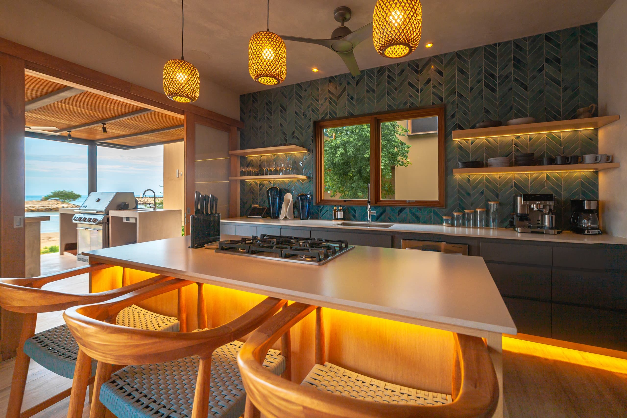 Fully equipped kitchen with a gas cooktop opening to the terrace and ocean