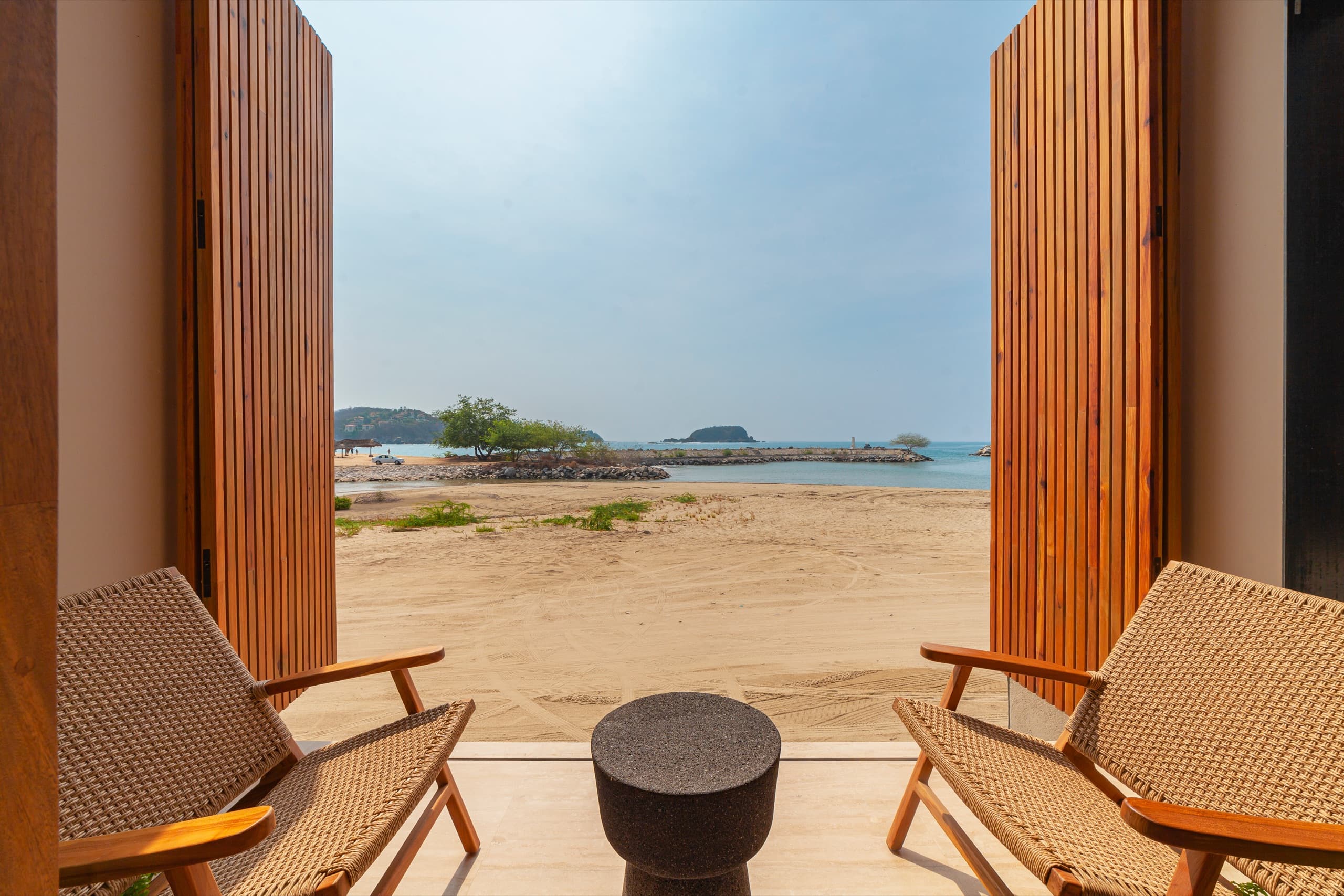 Open doors framing the beach from a shaded terrace